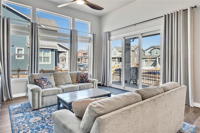 living room with a wealth of natural light, baseboards, and a ceiling fan