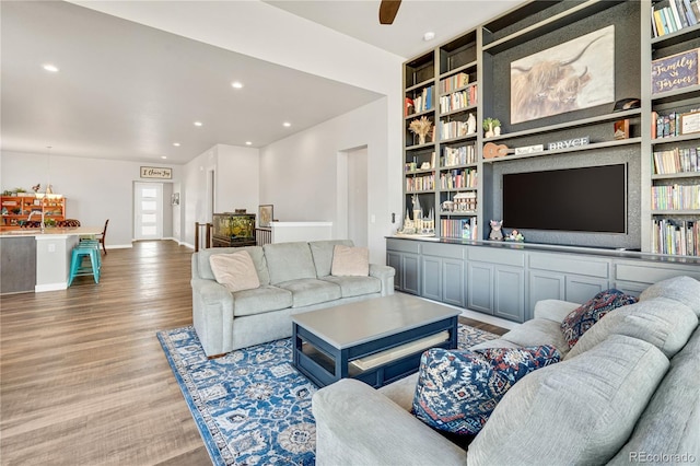 living area with recessed lighting, baseboards, ceiling fan, built in features, and wood finished floors