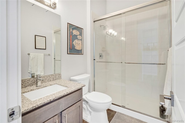 full bathroom with vanity, toilet, and a shower stall