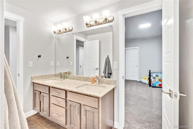 full bathroom featuring a sink, double vanity, and baseboards