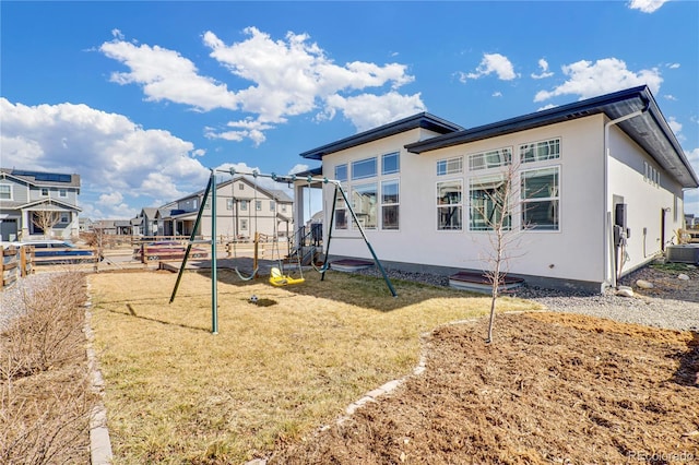 exterior space with a yard, central air condition unit, a residential view, and fence