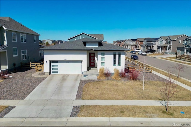 view of front facade with roof with shingles, driveway, a residential view, a garage, and stucco siding
