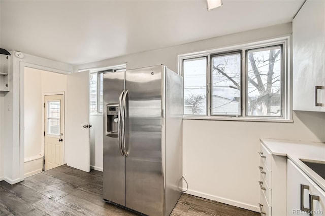 kitchen featuring dark wood-type flooring, white cabinets, stainless steel fridge with ice dispenser, and light countertops