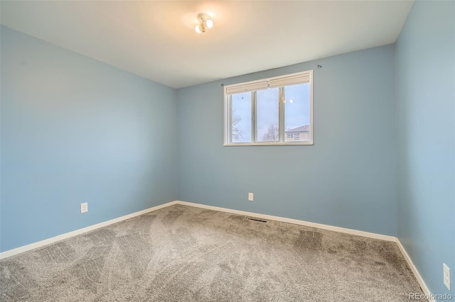 carpeted spare room featuring visible vents and baseboards