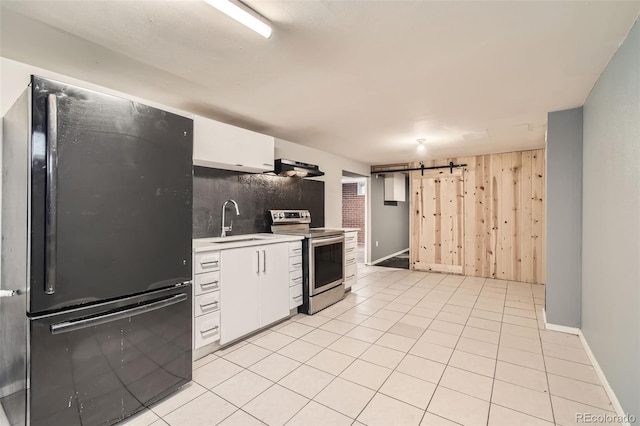 kitchen featuring freestanding refrigerator, a sink, light countertops, stainless steel range with electric stovetop, and a barn door