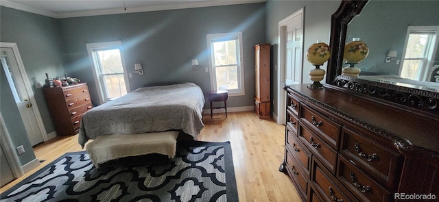 bedroom with light hardwood / wood-style floors and crown molding