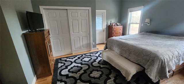 bedroom with light hardwood / wood-style floors and a closet