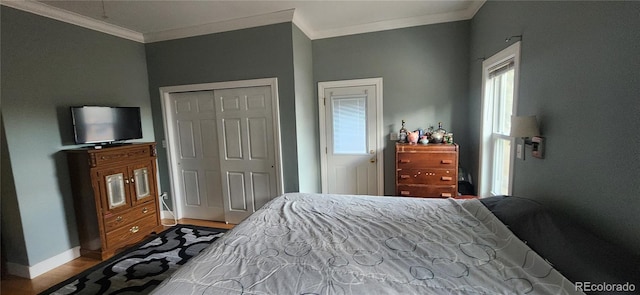 bedroom featuring light wood-type flooring, a closet, and crown molding