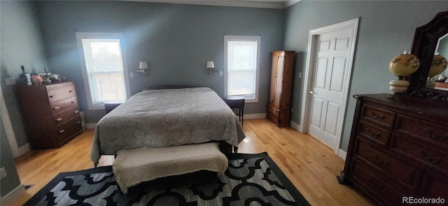 bedroom featuring multiple windows and light hardwood / wood-style floors