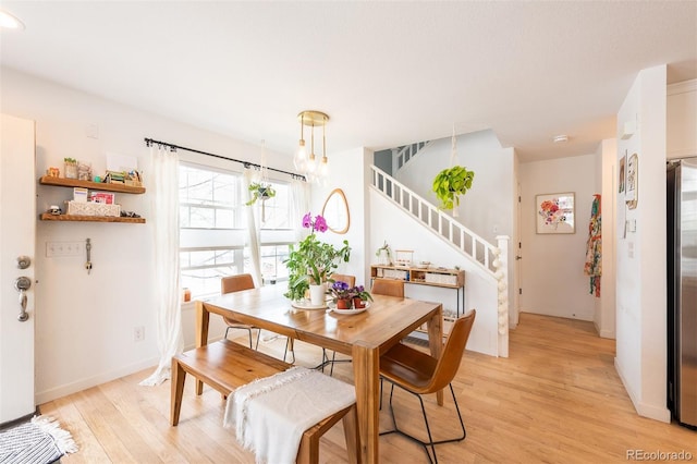 661 Snowberry St, Longmont, CO 80503 - dining room with baseboards, a notable chandelier, stairs, and light wood-style flooring