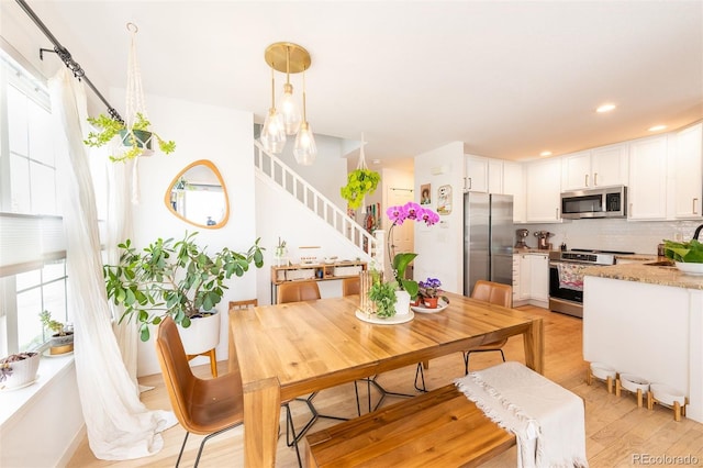 661 Snowberry St, Longmont, CO 80503 - dining area featuring recessed lighting, light wood-style floors, and stairs