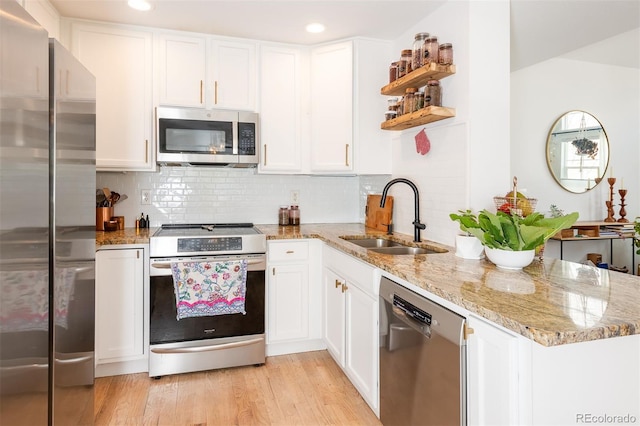 661 Snowberry St, Longmont, CO 80503 - kitchen with open shelves, a sink, a peninsula, appliances with stainless steel finishes, and white cabinetry