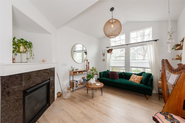 661 Snowberry St, Longmont, CO 80503 - living area featuring light wood-style flooring, a glass covered fireplace, and high vaulted ceiling