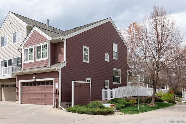 661 Snowberry St, Longmont, CO 80503 - view of side of home featuring fence, a shingled roof, driveway, and a garage