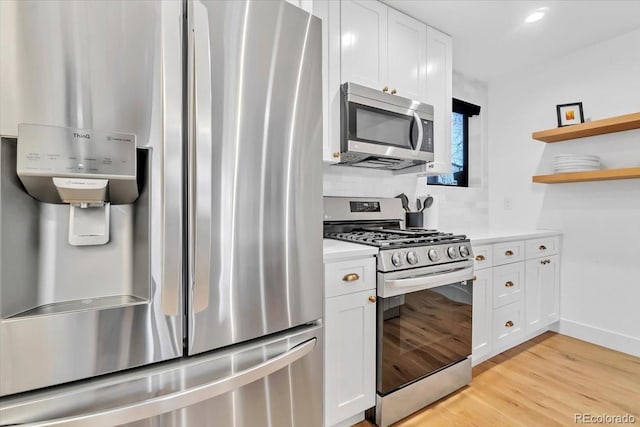 kitchen featuring appliances with stainless steel finishes, white cabinetry, and light hardwood / wood-style floors