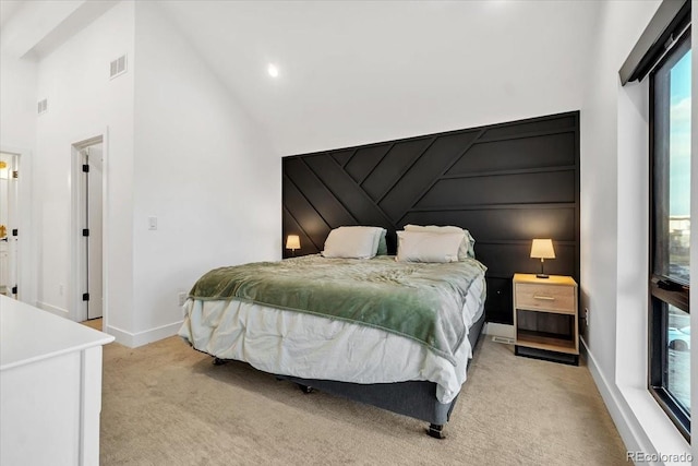 bedroom featuring high vaulted ceiling, light carpet, and multiple windows