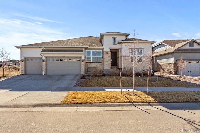 prairie-style home featuring driveway, an attached garage, and stucco siding