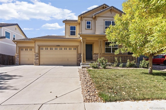 craftsman inspired home with a porch, a front lawn, and a garage