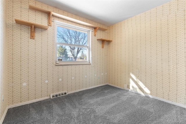 carpeted empty room featuring visible vents, baseboards, and wallpapered walls