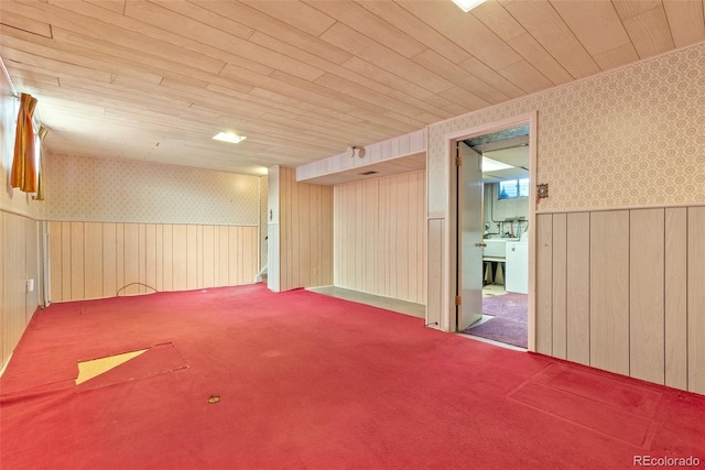 carpeted empty room with wooden ceiling, a wainscoted wall, and wallpapered walls