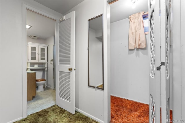 interior space featuring toilet, vanity, and baseboards