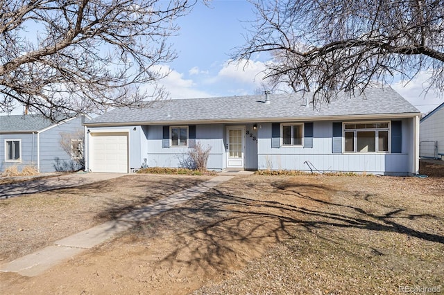 ranch-style house with a garage and roof with shingles