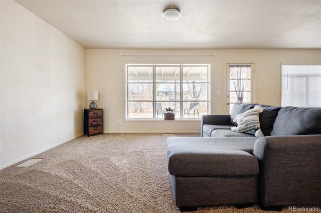 carpeted living area with plenty of natural light, visible vents, and baseboards