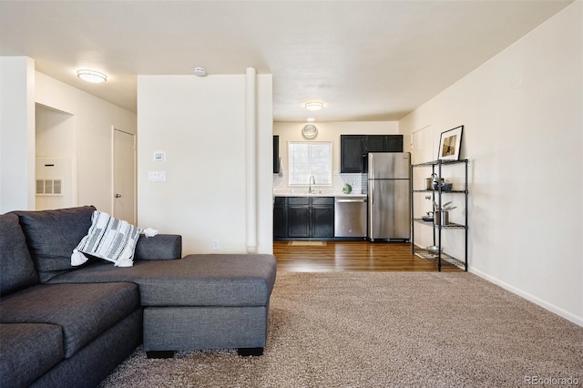 living area featuring visible vents, dark carpet, and baseboards