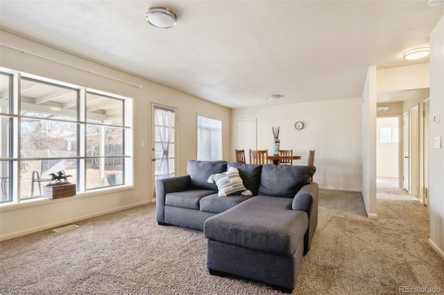 living room with baseboards, visible vents, and carpet flooring