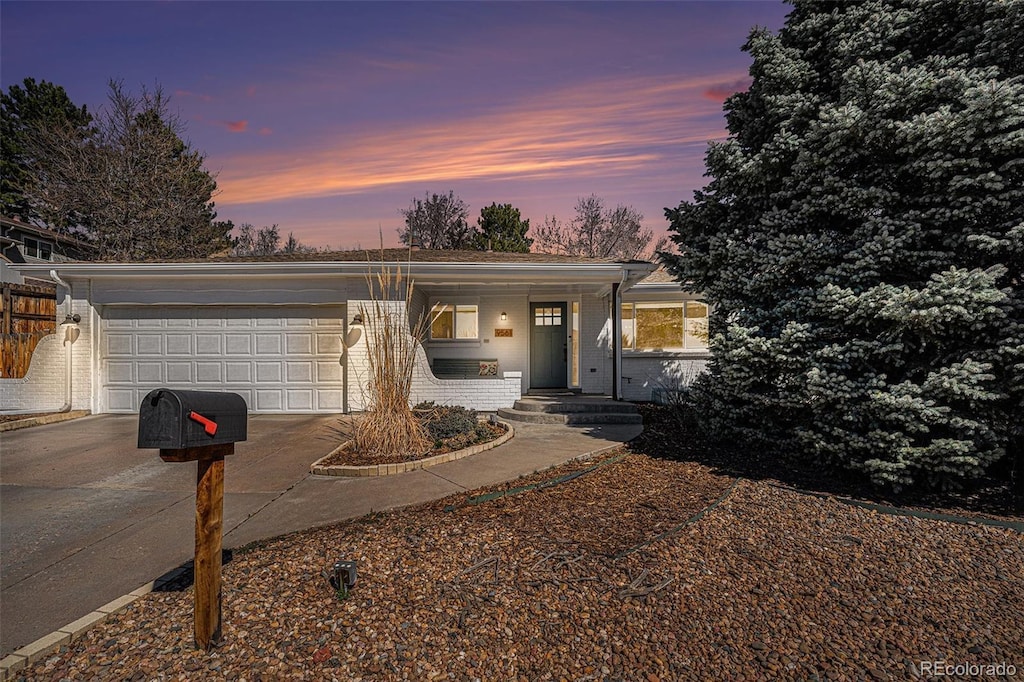 9561 W Wesley Dr, Lakewood, CO 80227 - view of front of home featuring concrete driveway, brick siding, and a garage