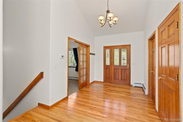 foyer with a wealth of natural light, a baseboard heating unit, and light wood-type flooring