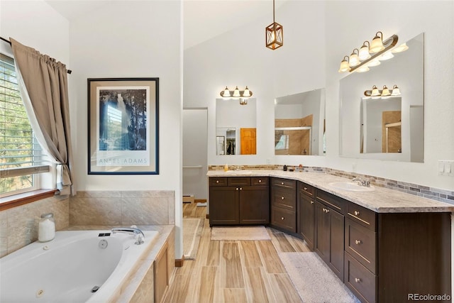 bathroom featuring vanity, hardwood / wood-style floors, separate shower and tub, and high vaulted ceiling