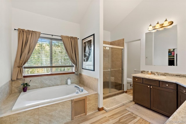 full bathroom with lofted ceiling, toilet, independent shower and bath, hardwood / wood-style floors, and vanity