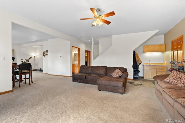 living room featuring light carpet, sink, and ceiling fan