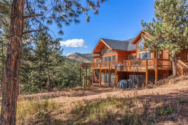 rear view of house with a deck with mountain view