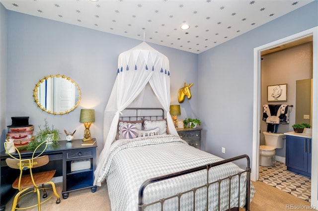 carpeted bedroom featuring ensuite bath