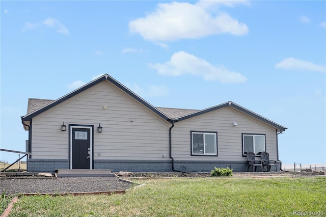 rear view of property featuring a lawn