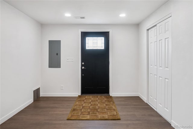 foyer entrance with baseboards, electric panel, visible vents, and dark wood-type flooring