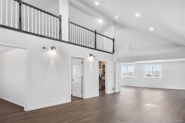 unfurnished living room with baseboards, beam ceiling, visible vents, and wood finished floors