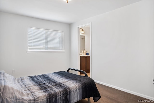 bedroom featuring ensuite bath, wood finished floors, and baseboards