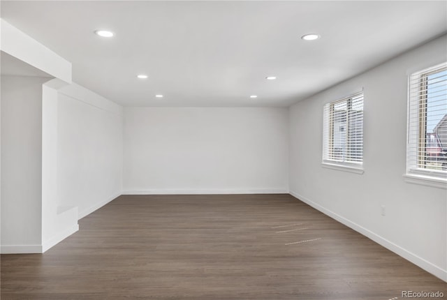 unfurnished room featuring baseboards, wood finished floors, and recessed lighting