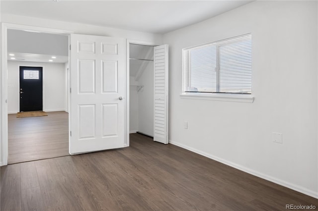 unfurnished bedroom with a closet, wood finished floors, and baseboards