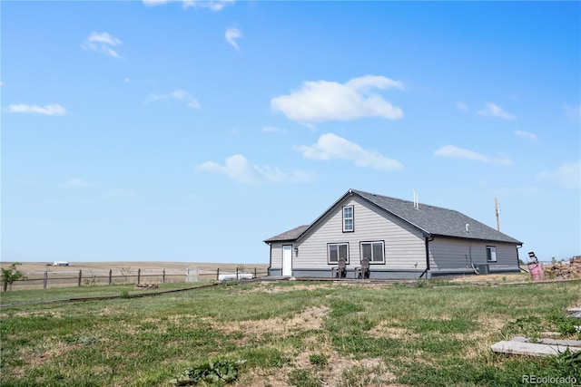 back of property with fence and a lawn