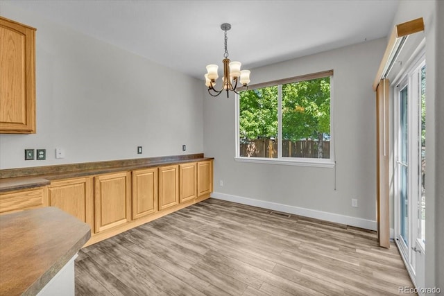 2142 Paint Pony Cir, Castle Rock, CO 80108 - kitchen featuring light wood-style floors, a chandelier, decorative light fixtures, and dark countertops