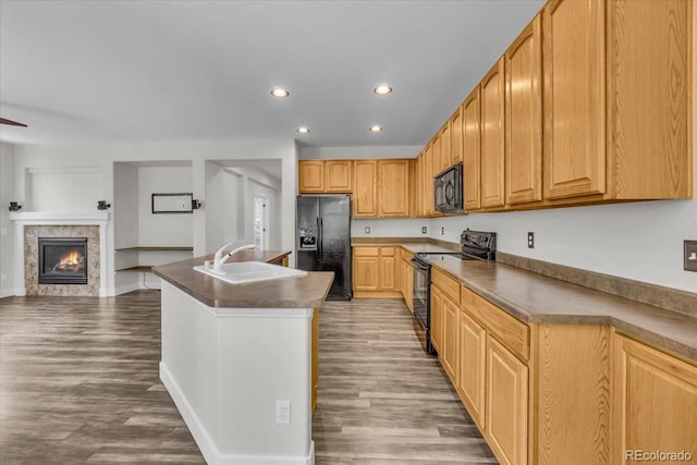 2142 Paint Pony Cir, Castle Rock, CO 80108 - kitchen featuring black appliances, recessed lighting, wood finished floors, dark countertops, and a kitchen island with sink