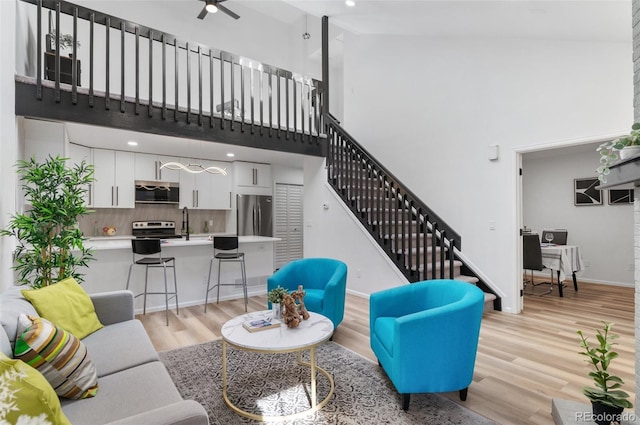 living room featuring a towering ceiling and light hardwood / wood-style flooring