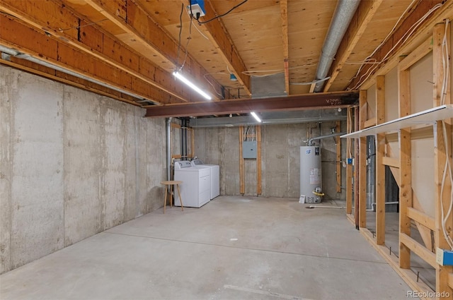 basement featuring electric panel, washing machine and dryer, and water heater