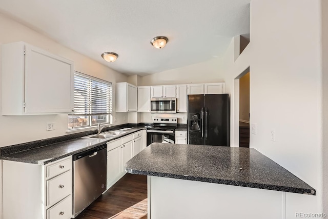 kitchen featuring dark wood-type flooring, stainless steel appliances, lofted ceiling, white cabinets, and sink