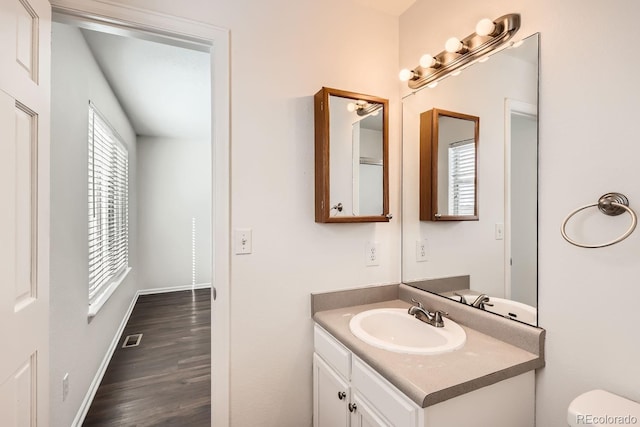 bathroom featuring toilet, wood-type flooring, and vanity