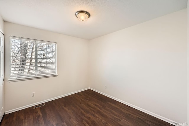 empty room with dark hardwood / wood-style flooring